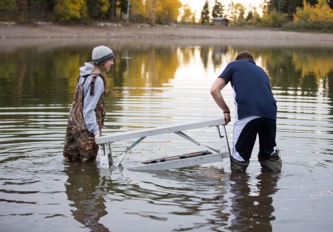Bella Torgerson and Todd Wakefield find the perfect place for the platform in the mud. Photo by Jaren Wilkey/BYU Photo